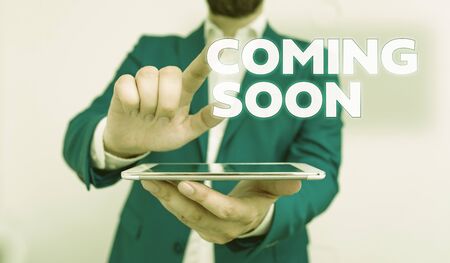 Word writing text Coming Soon. Business photo showcasing something is going to happen in really short time of period Businessman with pointing finger in front of himの写真素材