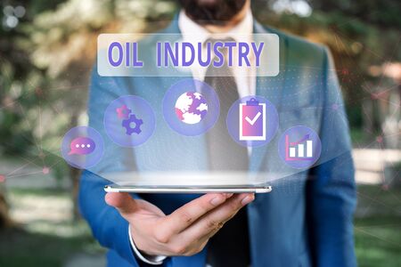 Handwriting text Oil Industry. Conceptual photo Exploration Extraction Refining Marketing petroleum products Male human wear formal work suit presenting presentation using smart deviceの写真素材