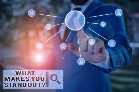 Text sign showing What Makes You Stand Out Question. Business photo text asking someone about his qualities Male human wear formal work suit presenting presentation using smart deviceの写真素材
