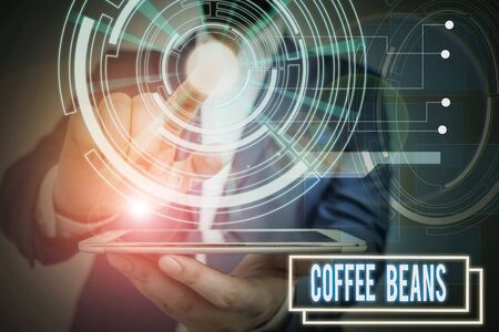 Text sign showing Coffee Beans. Business photo showcasing pit inside the red or purple fruit often referred as a cherry Male human wear formal work suit presenting presentation using smart deviceの写真素材
