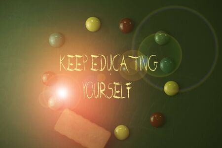 Word writing text Keep Educating Yourself. Business photo showcasing dont stop studying Improve yourself using Courses Round Flat shape stones with one eraser stick to old chalk black boardの写真素材