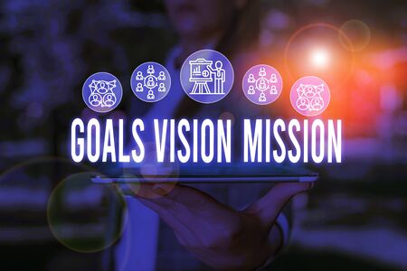 Handwriting text Goals Vision Mission. Conceptual photo practical planning process used to help community group Woman wear formal work suit presenting presentation using smart deviceの写真素材