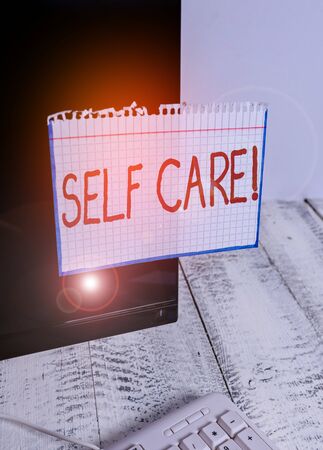 Text sign showing Self Care. Business photo text practice of taking action to preserve or improve ones own health Notation paper taped to black computer monitor screen near white keyboardの写真素材