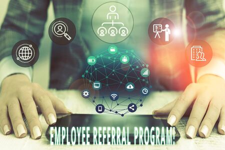 Conceptual hand writing showing Employee Referral Program. Concept meaning internal recruitment method employed by organizations Female human wear formal work suit presenting smart deviceの写真素材