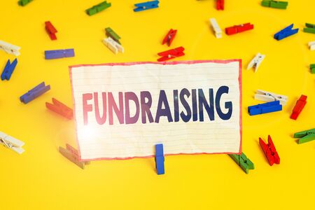 Conceptual hand writing showing Fundraising. Concept meaning act of collecting or producing money for a particular purpose Colored clothespin papers empty reminder yellow floor officeの写真素材