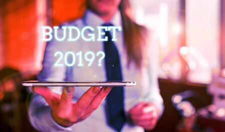 Word writing text Budget 2019 Question. Business photo showcasing estimate of income and expenditure for next year Blurred woman in the background pointing with finger in empty spaceの写真素材