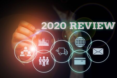 Handwriting text writing 2020 Review. Conceptual photo seeing important events or actions that made previous year Male human wear formal work suit presenting presentation using smart deviceの写真素材