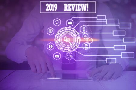 Writing note showing 2019 Review. Business concept for remembering past year events main actions or good shows Woman wear formal work suit present using smart latest deviceの写真素材
