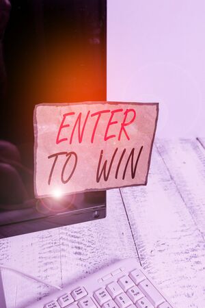 Writing note showing Enter To Win. Business concept for exchanging something value for prize or chance of winning Notation paper computer monitor screen near white keyboardの写真素材