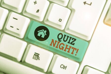 Text sign showing Quiz Night. Business photo text evening test knowledge competition between individuals White pc keyboard with empty note paper above white background key copy spaceの写真素材