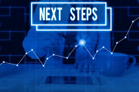 Writing note showing Next Steps. Business concept for something you do or plan after you ve finished something else Woman wear formal work suit present using smart latest deviceの写真素材