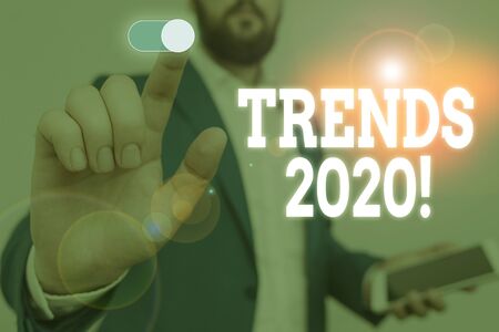 Handwriting text writing Trends 2020. Conceptual photo general direction in which something is developing or changing Male human wear formal work suit presenting presentation using smart deviceの写真素材