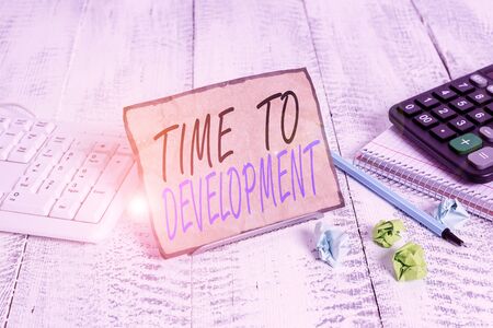 Writing note showing Time To Development. Business concept for a length of time during which a company grows or develop Notepaper on wire in between computer keyboard and sheetsの写真素材