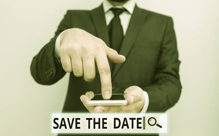 Text sign showing Save The Date question. Business photo text asking someone to remember specific day or time Male human wear formal work suit hold smart hi tech smartphone use one handの写真素材
