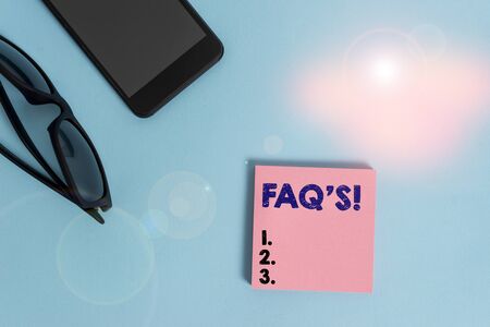 Text sign showing Faq S. Business photo showcasing list of questions and answers relating to particular subject Dark eyeglasses colored sticky note smartphone fashion pastel backgroundの写真素材