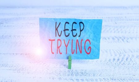 Word writing text Keep Trying. Business photo showcasing continue to do something or to do something again and again Green clothespin white wood background colored paper reminder office supplyの写真素材
