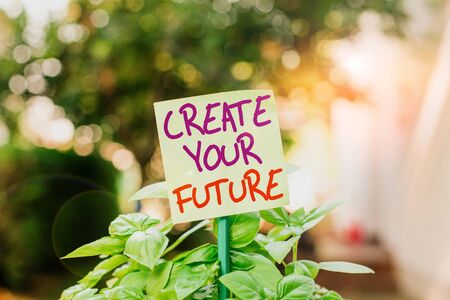 Handwriting text writing Create Your Future. Conceptual photo Set Target and Career goals Plan ahead Reach out Plain empty paper attached to a stick and placed in the green leafy plantsの写真素材