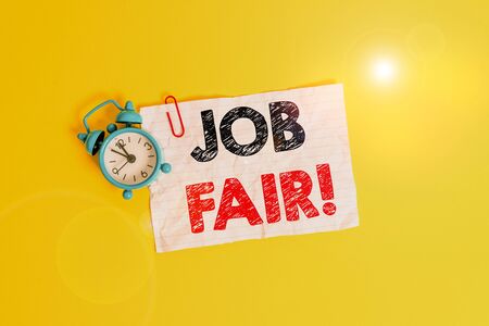 Text sign showing Job Fair. Business photo showcasing event where employers offer information about their companies Metal alarm clock clip blank crushed note sheet colored backgroundの写真素材