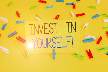 Text sign showing Invest In Yourself. Business photo text nvesting in a coach or a training to learn new things Colored clothespin papers empty reminder yellow floor background officeの写真素材