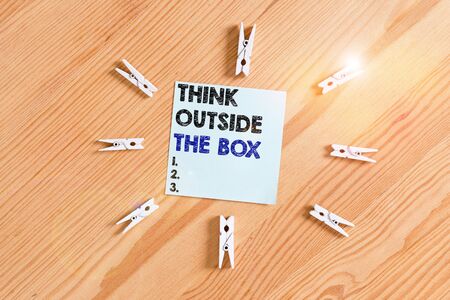 Word writing text Think Outside The Box. Business photo showcasing Be unique different ideas bring brainstorming Colored clothespin papers empty reminder wooden floor background officeの写真素材