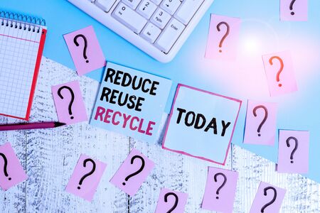 Conceptual hand writing showing Reduce Reuse Recycle. Concept meaning ways can eliminate waste protect your environment Writing tools and scribbled paper on top of the wooden tableの写真素材