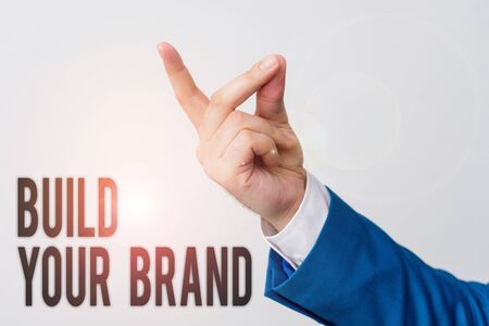 Handwriting text Build Your Brand. Conceptual photo enhancing brand equity using advertising campaigns Isolated hand pointing with finger. Business concept pointing fingerの写真素材