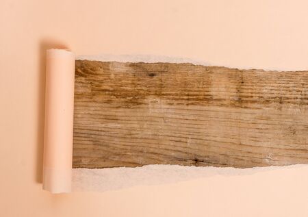 Cardboard which is torn in the middle placed above a wooden classic table