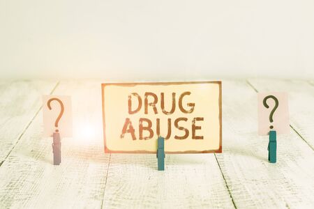 Text sign showing Drug Abuse. Business photo text the habitual taking of addictive or illegal chemical substances Scribbled and crumbling sheet with paper clips placed on the wooden tableの写真素材