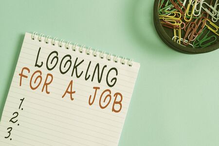 Writing note showing Looking For A Job. Business concept for Unemployed seeking work Recruitment Huanalysis Resources Blank empty notebook and stationary placed above pastel colour backdropの写真素材