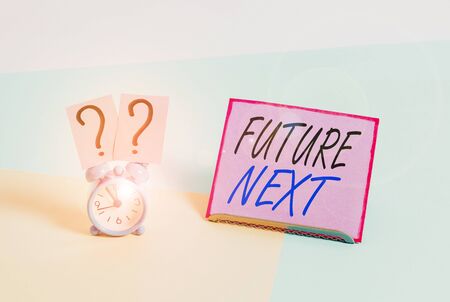 Word writing text Futuro Next. Business photo showcasing Set of mental process Huanalysis mind workflow Unique icons Mini size alarm clock beside a Paper sheet placed tilted on pastel backdropの写真素材