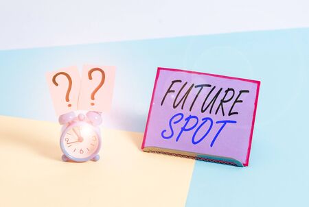 Word writing text Futuro Spot. Business photo showcasing refers to an action that will take place in the future Mini size alarm clock beside a Paper sheet placed tilted on pastel backdropの写真素材