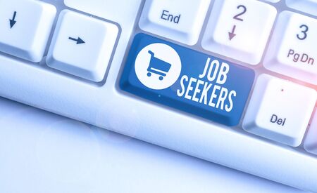 Writing note showing Job Seekers. Business concept for an unemployed demonstrating who is actively looking for employment White pc keyboard with note paper above the white backgroundの写真素材