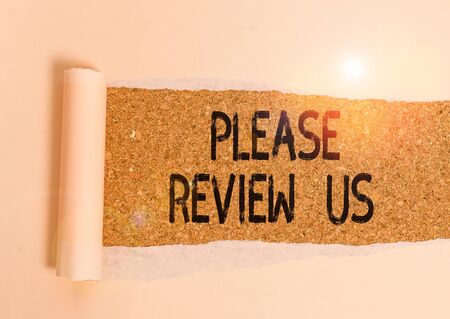 Conceptual hand writing showing Please Review Us. Concept meaning Give a feedback Opinion Comments Quality of service Cardboard which is torn placed above a wooden classic tableの写真素材