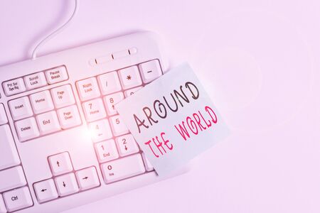 Writing note showing Around The World. Business concept for saying that something available all over globe everywhere White pc keyboard with empty note paper above white backgroundの写真素材