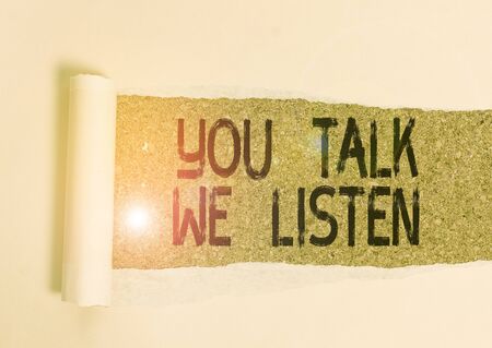 Conceptual hand writing showing You Talk We Listen. Concept meaning Two Way Communication Motivational Conversation Cardboard which is torn placed above a wooden classic tableの写真素材