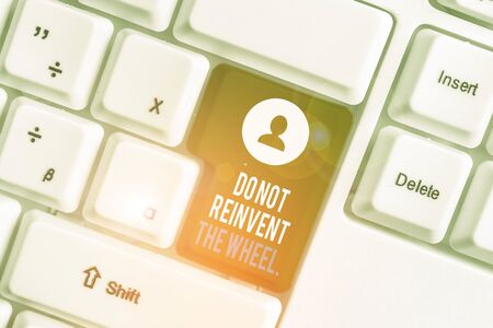 Writing note showing Do Not Reinvent The Wheel. Business concept for stop duplicating a basic method previously done White pc keyboard with note paper above the white backgroundの写真素材