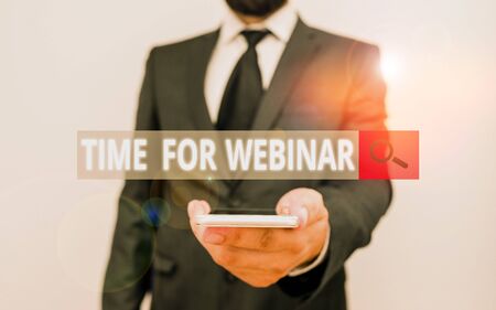 Word writing text Time For Webinar. Business photo showcasing seminar conducted over the Internet Web conferencing Male human wear formal work suit hold smart hi tech smartphone use one handの写真素材
