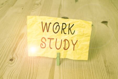 Conceptual hand writing showing Work Study. Concept meaning college program that enables students to work parttime Wooden floor background green clothespin groove slot officeの写真素材
