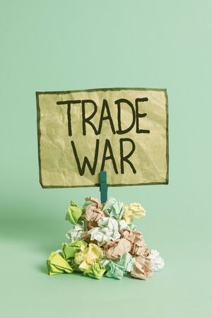 Word writing text Trade War. Business photo showcasing a situation in which countries try to damage each other s is trade Reminder pile colored crumpled paper clothespin reminder blue backgroundの写真素材