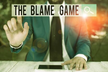 Conceptual hand writing showing The Blame Game. Concept meaning A situation when showing attempt to blame one another Businessman with pointing finger in front of himの写真素材