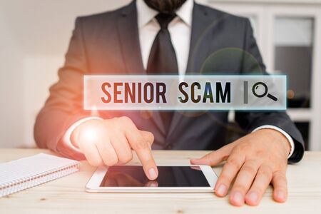 Conceptual hand writing showing Senior Scam. Concept meaning fraud schemes targeting the lifestyle and savings of the elderly Male human wear formal clothes present use hitech smartphoneの写真素材