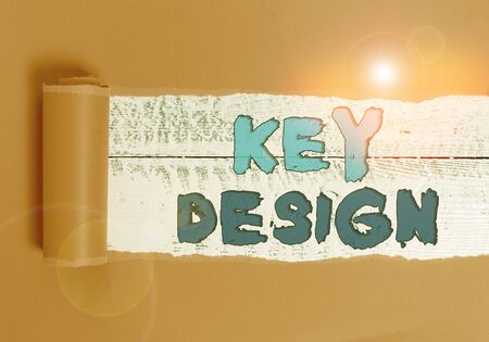 Word writing text Key Design. Business photo showcasing a necessary or very important realization of a concept or idea Cardboard which is torn in the middle placed above a wooden classic tableの写真素材