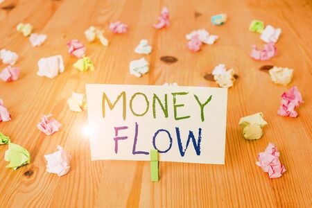 Conceptual hand writing showing Money Flow. Concept meaning the increase or decrease in the amount of money a business Colored crumpled papers wooden floor background clothespinの写真素材