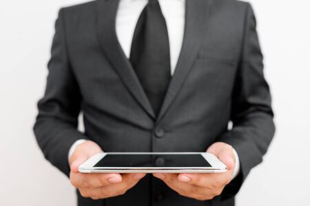 Male human wear formal work suit hold smart hi tech smartphone use handsの写真素材