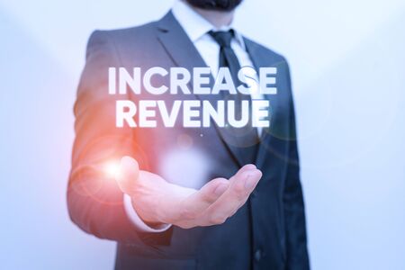 Conceptual hand writing showing Increase Revenue. Concept meaning increase in a company s is sales from one period to the next Male human with beard wear formal working suit clothes handの写真素材