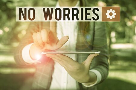 Text sign showing No Worries. Business photo text an expression used to say that everything is all right Outdoor scene with business woman holds lap top with touch screenの写真素材