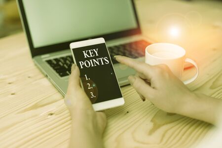 Conceptual hand writing showing Key Points. Concept meaning most important piece of information that is said or written woman with laptop smartphone and office supplies technologyの写真素材