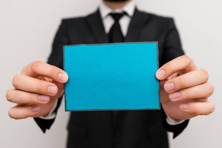 Male human wear formal work suit office look hold notepaper sheet use handの写真素材