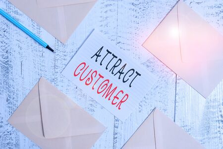 Conceptual hand writing showing Attract Customer. Concept meaning to bring more customers or clients to your store or website Envelopes highlighter ruled paper sheet wooden vintage backgroundの写真素材