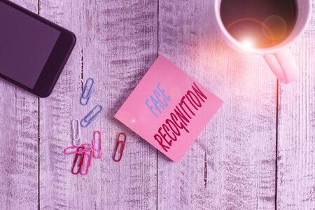 Text sign showing Face Recognition. Business photo text ability of a computer to scan and recognize huanalysis faces Stationary placed next to a cup of black coffee above the wooden tableの写真素材